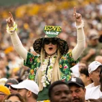 Woman cheering on the Packers decked out in team apparel and hat
